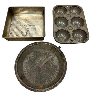 Sale Photo Thumbnail #411: Lot of 3 Vintage Metal Bakeware Baking Pieces
Bake-Rite Square Cake Pan, Bake King round cake pan with rotating insert, and 6 Cup Muffin/Cupcake Mold. All show age and patina consistent with vintage use.