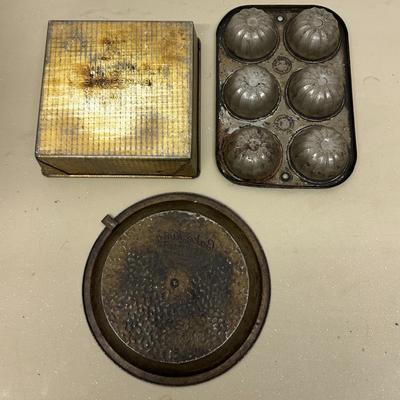 Sale Photo Thumbnail #410: Lot of 3 Vintage Metal Bakeware Baking Pieces
Bake-Rite Square Cake Pan, Bake King round cake pan with rotating insert, and 6 Cup Muffin/Cupcake Mold. All show age and patina consistent with vintage use.