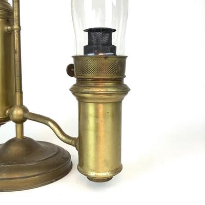 Sale Photo Thumbnail #1317: This is an old, heavy brass oil lamp made by Miller. It has a tarnished brass finish and a turnable body. The glass globe is an Aladdin brand and has a small chip on the bottom that's hidden when attached. The word "Miller" is stamped on the bottom and "E
