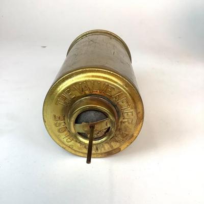 Sale Photo Thumbnail #1315: This is an old, heavy brass oil lamp made by Miller. It has a tarnished brass finish and a turnable body. The glass globe is an Aladdin brand and has a small chip on the bottom that's hidden when attached. The word "Miller" is stamped on the bottom and "E