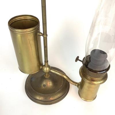 Sale Photo Thumbnail #1313: This is an old, heavy brass oil lamp made by Miller. It has a tarnished brass finish and a turnable body. The glass globe is an Aladdin brand and has a small chip on the bottom that's hidden when attached. The word "Miller" is stamped on the bottom and "E