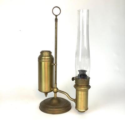 Sale Photo Thumbnail #1319: This is an old, heavy brass oil lamp made by Miller. It has a tarnished brass finish and a turnable body. The glass globe is an Aladdin brand and has a small chip on the bottom that's hidden when attached. The word "Miller" is stamped on the bottom and "E