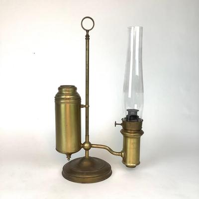 Sale Photo Thumbnail #1320: This is an old, heavy brass oil lamp made by Miller. It has a tarnished brass finish and a turnable body. The glass globe is an Aladdin brand and has a small chip on the bottom that's hidden when attached. The word "Miller" is stamped on the bottom and "E