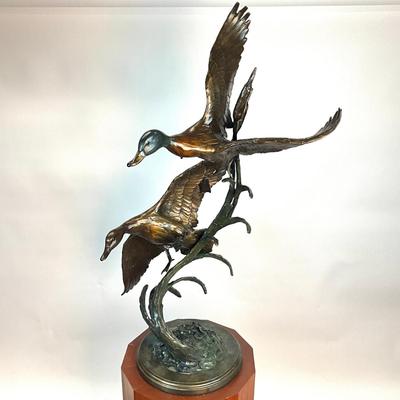 Sale Photo Thumbnail #1405: Against the Wind is an elegant rendition of a pair of mallards cutting through the wind for a landing .  The design incorporates beautiful "S" curves and circular motion rising out of an integrated formal bronze base.  This piece is suitable for indoor, o