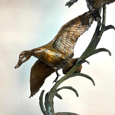 Sale Photo Thumbnail #1404: Against the Wind is an elegant rendition of a pair of mallards cutting through the wind for a landing .  The design incorporates beautiful "S" curves and circular motion rising out of an integrated formal bronze base.  This piece is suitable for indoor, o