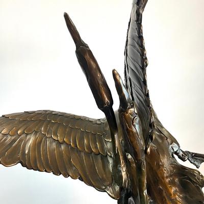 Sale Photo Thumbnail #1397: Against the Wind is an elegant rendition of a pair of mallards cutting through the wind for a landing .  The design incorporates beautiful "S" curves and circular motion rising out of an integrated formal bronze base.  This piece is suitable for indoor, o