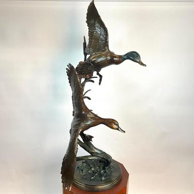 Sale Photo Thumbnail #1402: Against the Wind is an elegant rendition of a pair of mallards cutting through the wind for a landing .  The design incorporates beautiful "S" curves and circular motion rising out of an integrated formal bronze base.  This piece is suitable for indoor, o