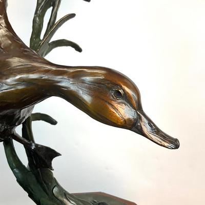 Sale Photo Thumbnail #1400: Against the Wind is an elegant rendition of a pair of mallards cutting through the wind for a landing .  The design incorporates beautiful "S" curves and circular motion rising out of an integrated formal bronze base.  This piece is suitable for indoor, o