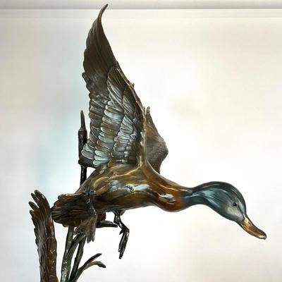 Sale Photo Thumbnail #1401: Against the Wind is an elegant rendition of a pair of mallards cutting through the wind for a landing .  The design incorporates beautiful "S" curves and circular motion rising out of an integrated formal bronze base.  This piece is suitable for indoor, o