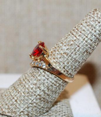 Size 6¾ Red 3 Prong Single Center Stone Ring with a "V" Accent of Clear Stones on a Gold Tone Band (2.8g)