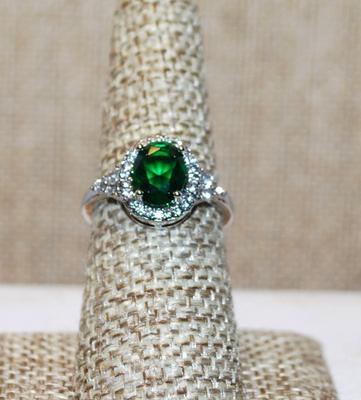 Size 7 Single Green Oval Cut Center Stone Ring with Full Surround on a Silver Tone Band (3.7g)