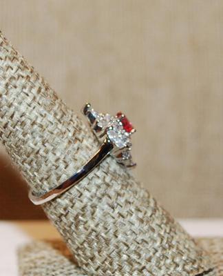 Size 7 Small Oval Red Center Stone Ring with Full "Diamond" Shaped Surround on a Silver Tone Band (2.5g)