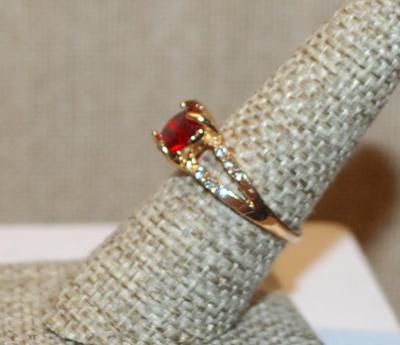 Size 7½ Single Clear Red Round Stone Ring with 2 Rows Side Accent Stones on a Gold Tone Band (2.4g)