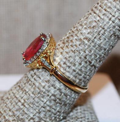 Size 8¼ Light Red Oval Cut Transparent Stone Ring with Full Clear Stones Surround and Side Accents on a Gold Tone Band (3.3g)
