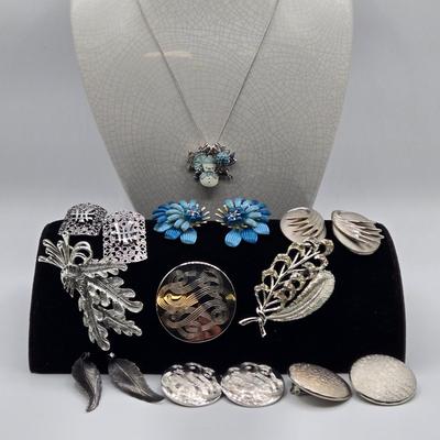 LOT 93: Multiple Pairs of Clip Earrings, Brooches, Silver-tone Chain with Winter Charms, and More