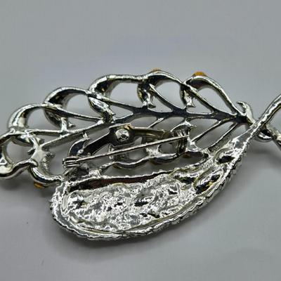 LOT 93: Multiple Pairs of Clip Earrings, Brooches, Silver-tone Chain with Winter Charms, and More