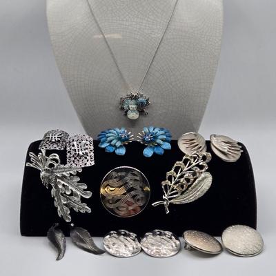 LOT 93: Multiple Pairs of Clip Earrings, Brooches, Silver-tone Chain with Winter Charms, and More