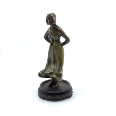 Sale Photo Thumbnail #1568: Beautiful woman standing with wind blowing skirt bronze figure. Mounted on round base , has a cut over top of her left foot around ankle area. Measuring 6.25" high