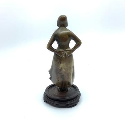 Sale Photo Thumbnail #1569: Beautiful woman standing with wind blowing skirt bronze figure. Mounted on round base , has a cut over top of her left foot around ankle area. Measuring 6.25" high