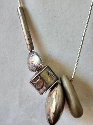 Sale Photo Thumbnail #168: 1989   30 Inch necklace with embossed pillow charms, hollow fabricated silver forms.  Signed.  
Her jewelry has SOLD prices ranging from $450 to $1150