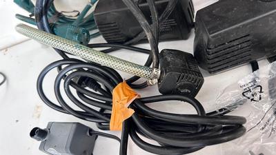 AN ASSORTMENT OF DIFFERENT PUMPS FOR PONDS AND AN OUTDOOR EXTENSION CORD