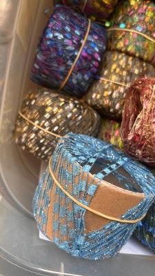 A TOTE PACKED WITH A BUNCH OF CRAFTING STRING/THREAD