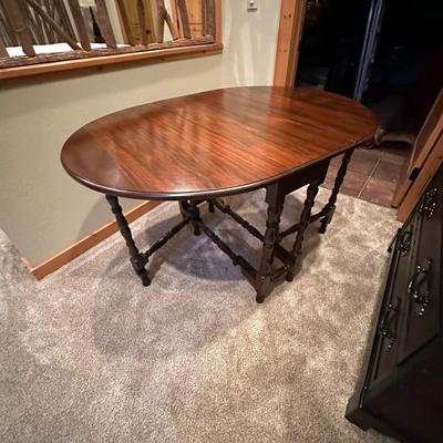 Sale Photo Thumbnail #117: Vintage Gateleg Drop Leaf Table with hinged leaves on both sides that can be raised or folded down.  The leaves are supported by extra legs that swing out.
Full m'ments:
 48" Wide
35" Deep
12" Deep with both sides down