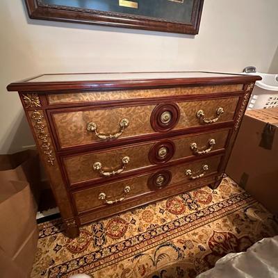 Sale Photo Thumbnail #234: Eglomise Handcrafted 3 Drawer Dresser by Theodore Alexander
Measurements: 46" WIde x 34" Tall x 20" Deep
"Eglomise" refers to a decorative technique using glass with metallic leaf applied to the reverse which Alexander used for many of his pieces.