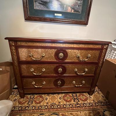 Sale Photo Thumbnail #236: Eglomise Handcrafted 3 Drawer Dresser by Theodore Alexander
Measurements: 46" WIde x 34" Tall x 20" Deep
"Eglomise" refers to a decorative technique using glass with metallic leaf applied to the reverse which Alexander used for many of his pieces.