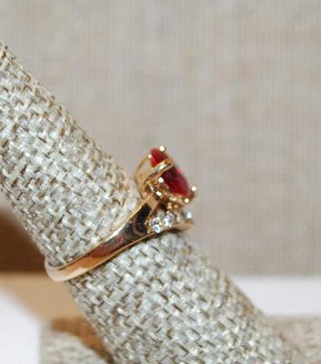 Size 6¾ Red 3 Prong Single Center Stone Ring with a "V" Accent of Clear Stones on a Gold Tone Band (2.8g)