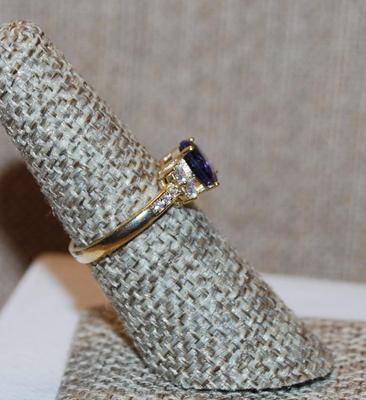 Size 7 Round Purple Stone Ring with Clear Stones Side Accents on a Gold Tone Band (2.4g)