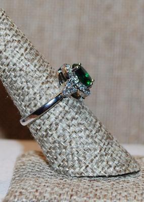 Size 7 Single Green Oval Cut Center Stone Ring with Full Surround on a Silver Tone Band (3.7g)