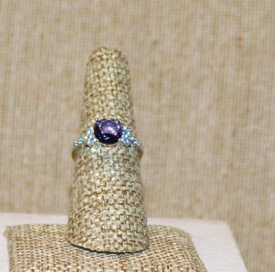 Size 7 Round Purple Stone Ring with Clear Stone Side Accents on a Gold Tone SPLIT BAND (2.4g)