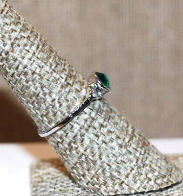 Size 7¼ Single Green Faceted Center Stone Set in a Round "Nest" Ring with 3 Clear Stones Side Accents and Silver Tone Band (1.7g)