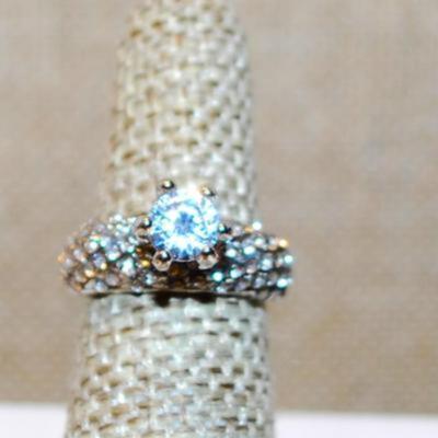 Size 6 Highrise Round Main Stone Ring with "Waves" of Accents Stones on a Silver Tone Band (4.1g)