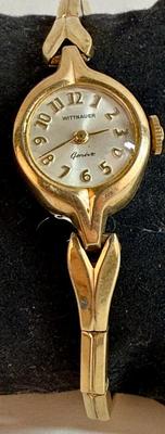 Sale Photo Thumbnail #76: Manual wind, in running condition. With a stretch-style band.  Round white watch dial. Swiss-made, 10K Rolled Gold Plate Bezel.