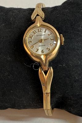 Sale Photo Thumbnail #77: Manual wind, in running condition. With a stretch-style band.  Round white watch dial. Swiss-made, 10K Rolled Gold Plate Bezel.