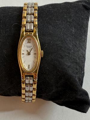 Sale Photo Thumbnail #53: Stainless steel finish with an oval case and white dial. Japan movement. Link-style band. Not running, likely needs a new battery.