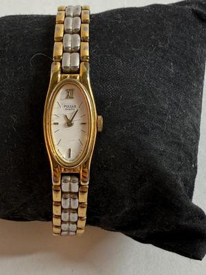 Sale Photo Thumbnail #52: Stainless steel finish with an oval case and white dial. Japan movement. Link-style band. Not running, likely needs a new battery.