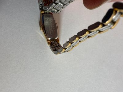 Sale Photo Thumbnail #56: Stainless steel finish with an oval case and white dial. Japan movement. Link-style band. Not running, likely needs a new battery.