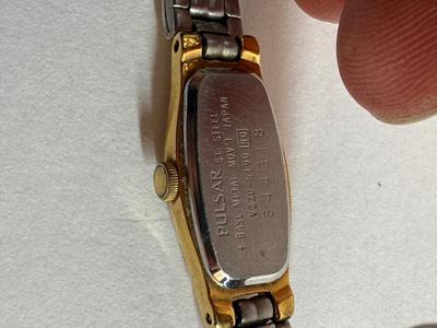 Sale Photo Thumbnail #55: Stainless steel finish with an oval case and white dial. Japan movement. Link-style band. Not running, likely needs a new battery.