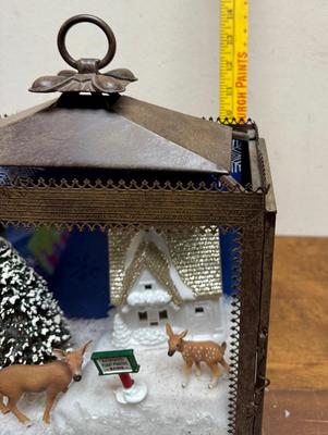 Sale Photo Thumbnail #361: This is a Christmas-themed lantern diorama featuring a "Reindeer Flight Practice Zone" scene. 
In good condition. Deer, sign, and tree are loose and can be rearranged.