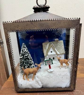 Sale Photo Thumbnail #365: This is a Christmas-themed lantern diorama featuring a "Reindeer Flight Practice Zone" scene. 
In good condition. Deer, sign, and tree are loose and can be rearranged.