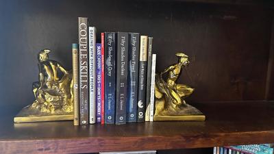 NATIVE AMERICAN THEMED BRASS BOOKENDS AND A VARIETY OF BOOKS