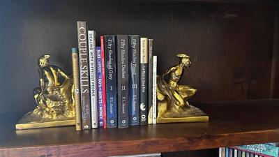 NATIVE AMERICAN THEMED BRASS BOOKENDS AND A VARIETY OF BOOKS