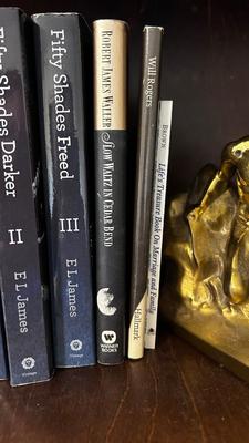 NATIVE AMERICAN THEMED BRASS BOOKENDS AND A VARIETY OF BOOKS