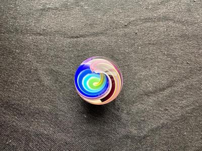 A VIBRANT MULTICOLORED MARBLE WITH A SWIRLING RAINBOW DESIGN