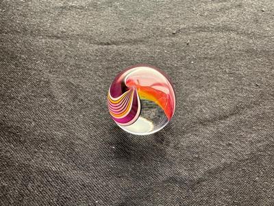 A VIBRANT MULTICOLORED MARBLE WITH A SWIRLING RAINBOW DESIGN