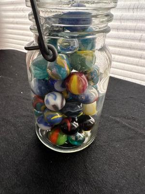 A JAR AND UNOPENED BAG OF MARBLES