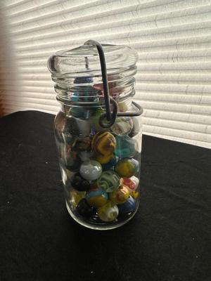 A JAR AND UNOPENED BAG OF MARBLES
